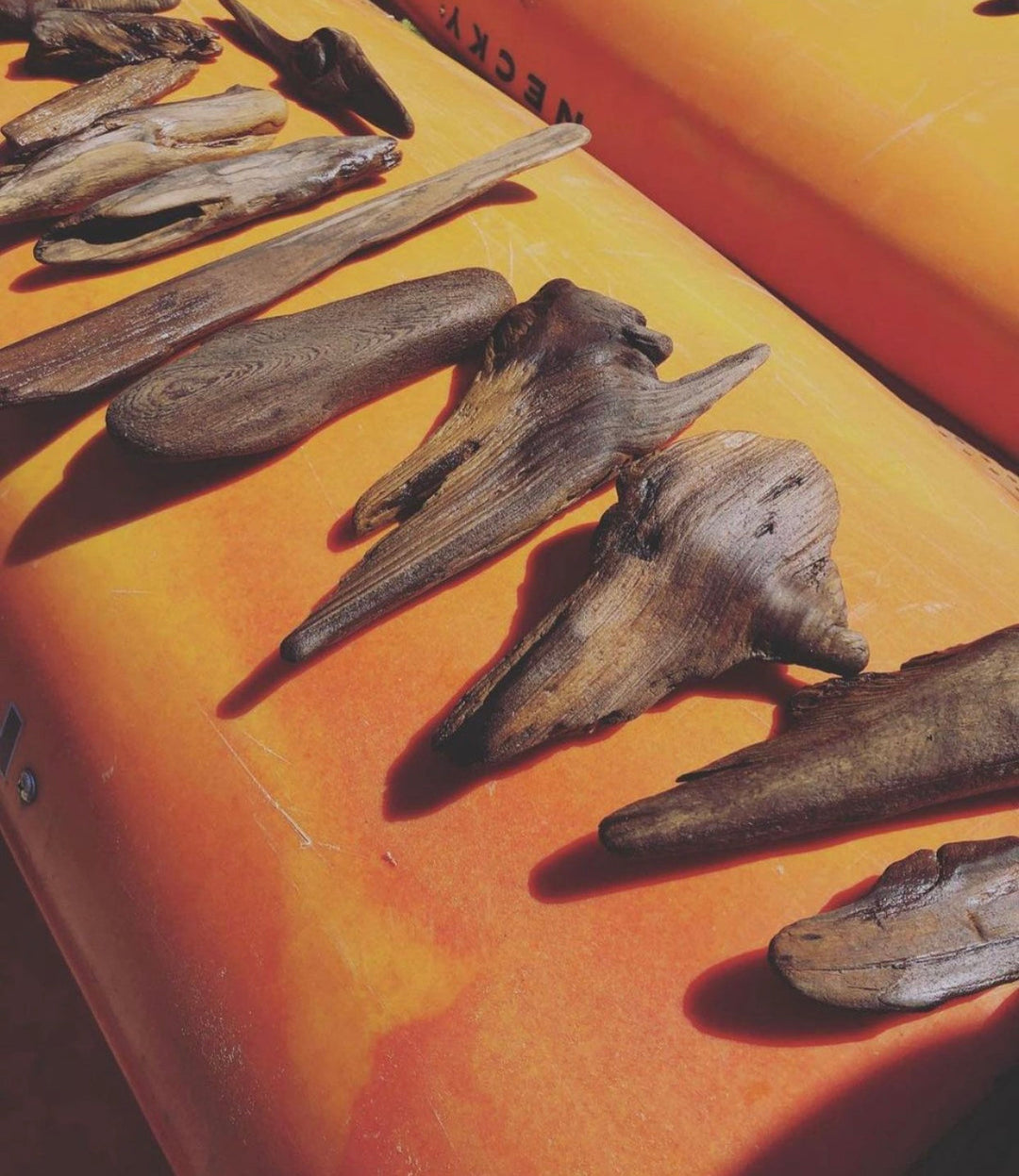 Close-up of dark driftwood wall sculpture pieces with gold backing disks on board