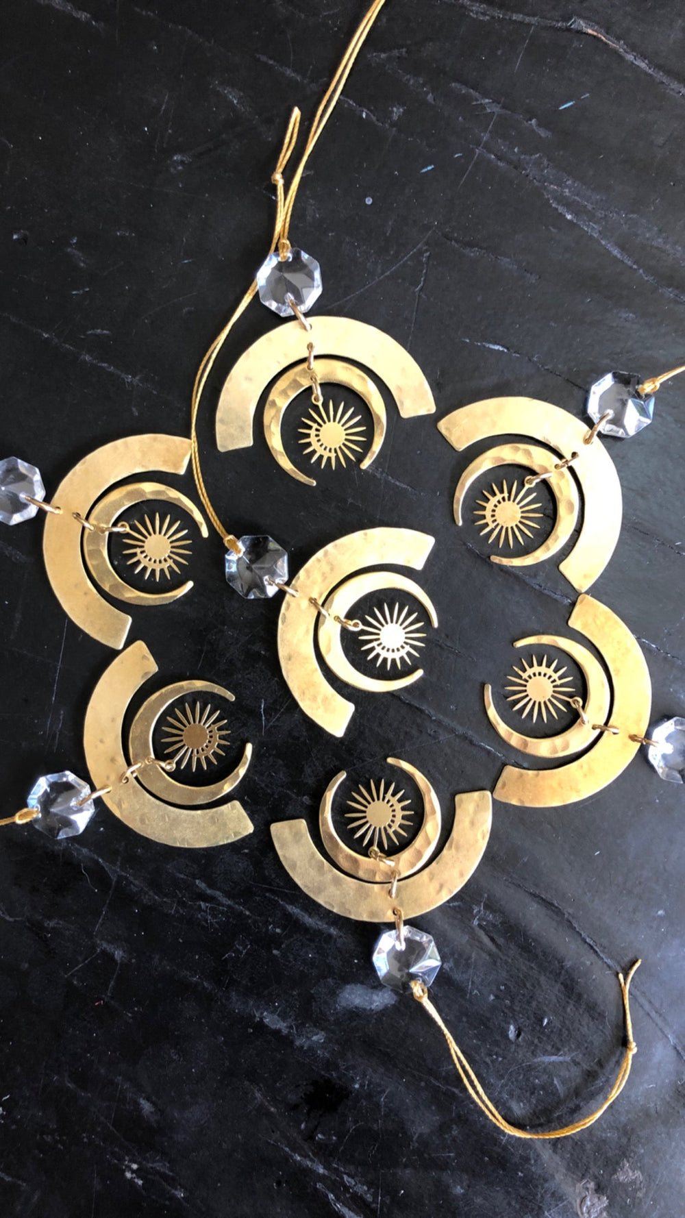 Gold-tone geometric crescent ornament cluster with clear glass crystals and sunburst discs.