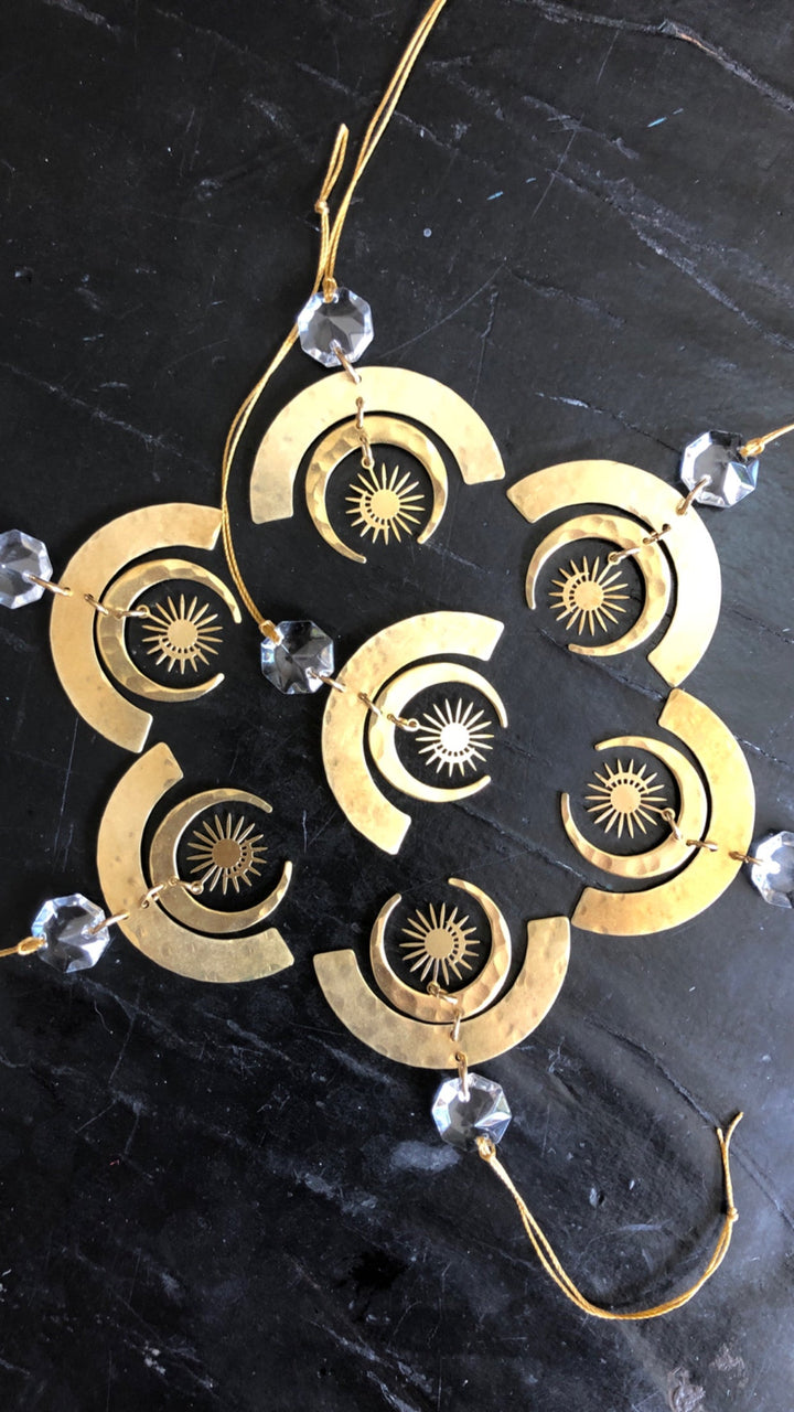 Gold-tone geometric crescent ornament cluster with clear glass crystals and sunburst discs.