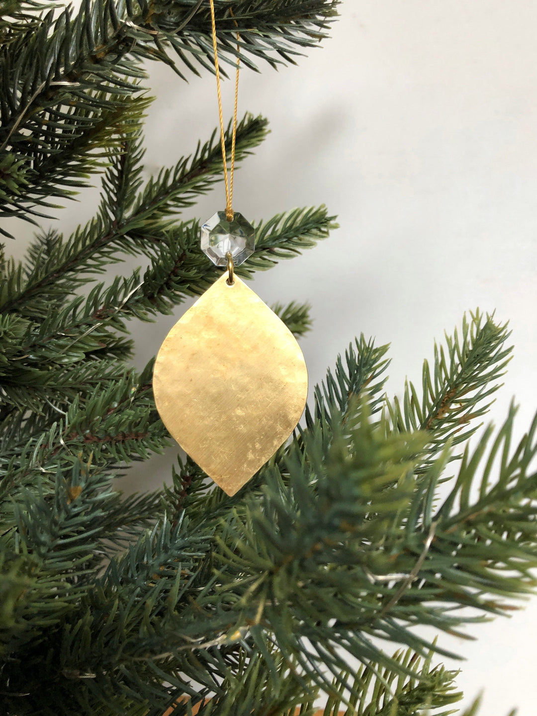 Gold teardrop ornament with clear faceted crystal bead top and gold hanging cord