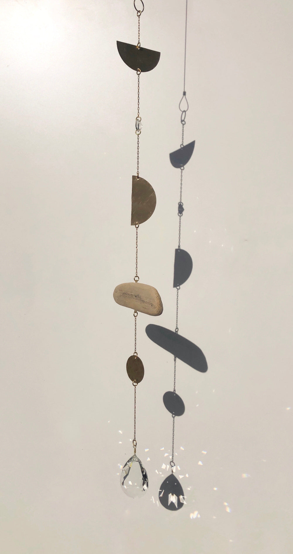 Hanging suncatcher with dark crescent pieces and two dangling crystal drops