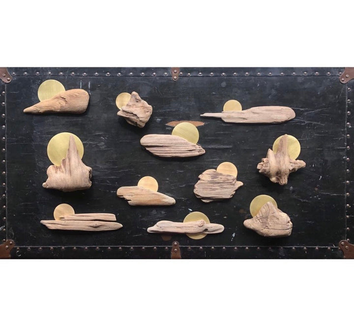Driftwood wall sculpture panel with multiple carved pieces and gold circular metal backing