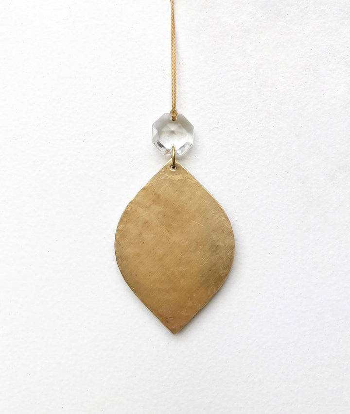 Gold teardrop ornament with clear crystal top on a hanging string