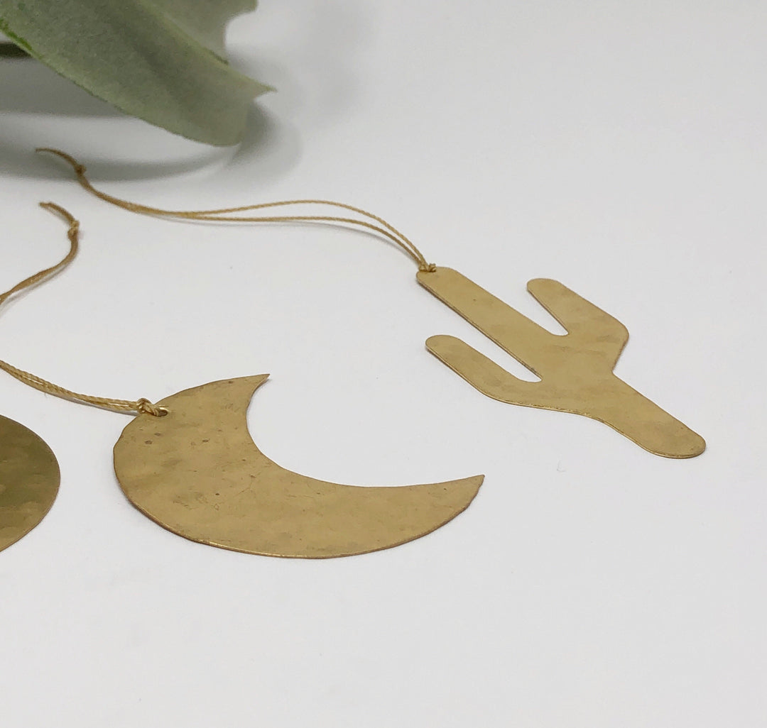 Gold-tone cactus and crescent moon ornaments with hanging string ties