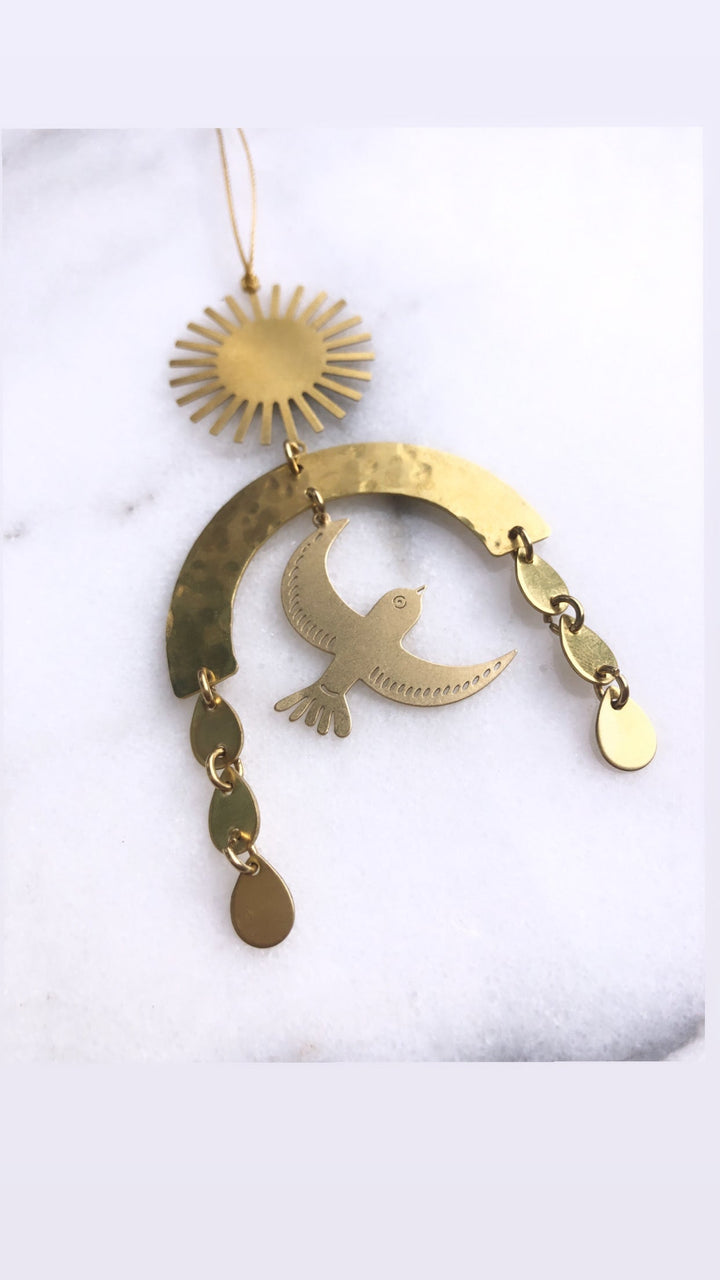 Hanging gold-toned crescent bird ornament with sun medallion and drop-shaped charms
