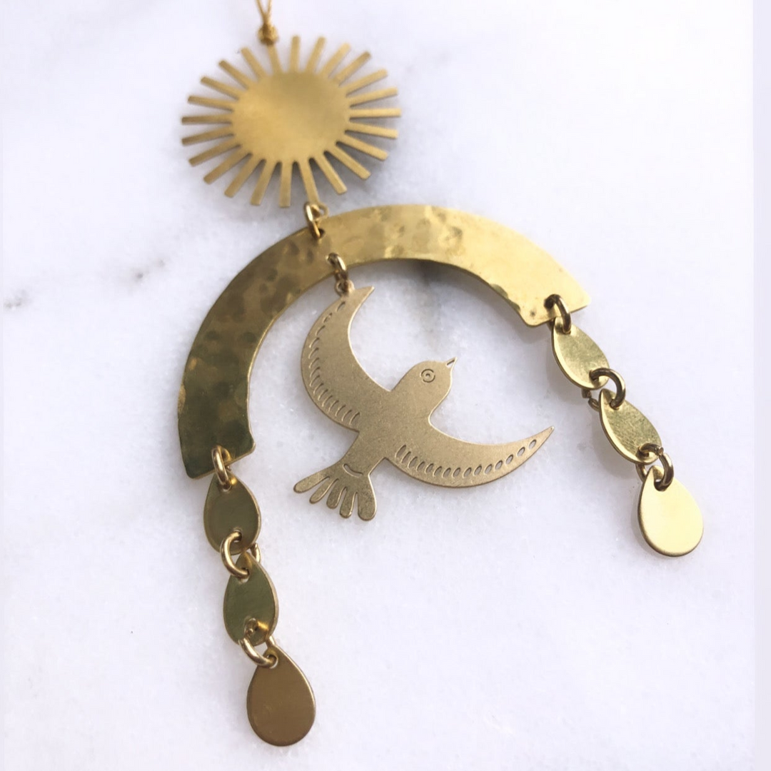 Gold-toned hanging bird on crescent ornament with small sun charm and dangling drops