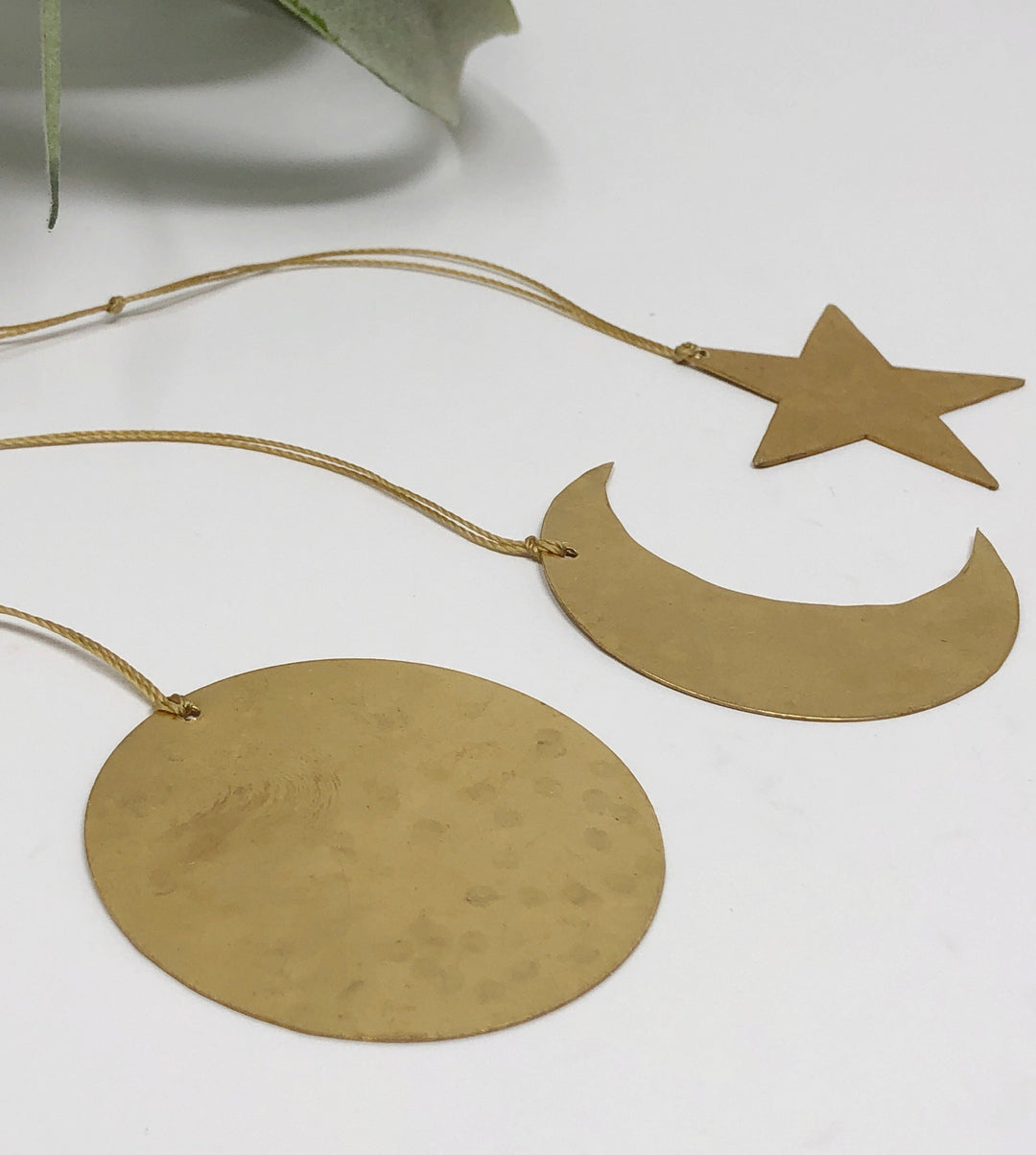 Gold round disk and crescent moon ornaments plus star ornament on hanging cords