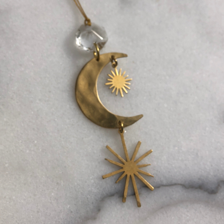 Gold crescent moon ornament with dangling sunburst charms and clear crystal top
