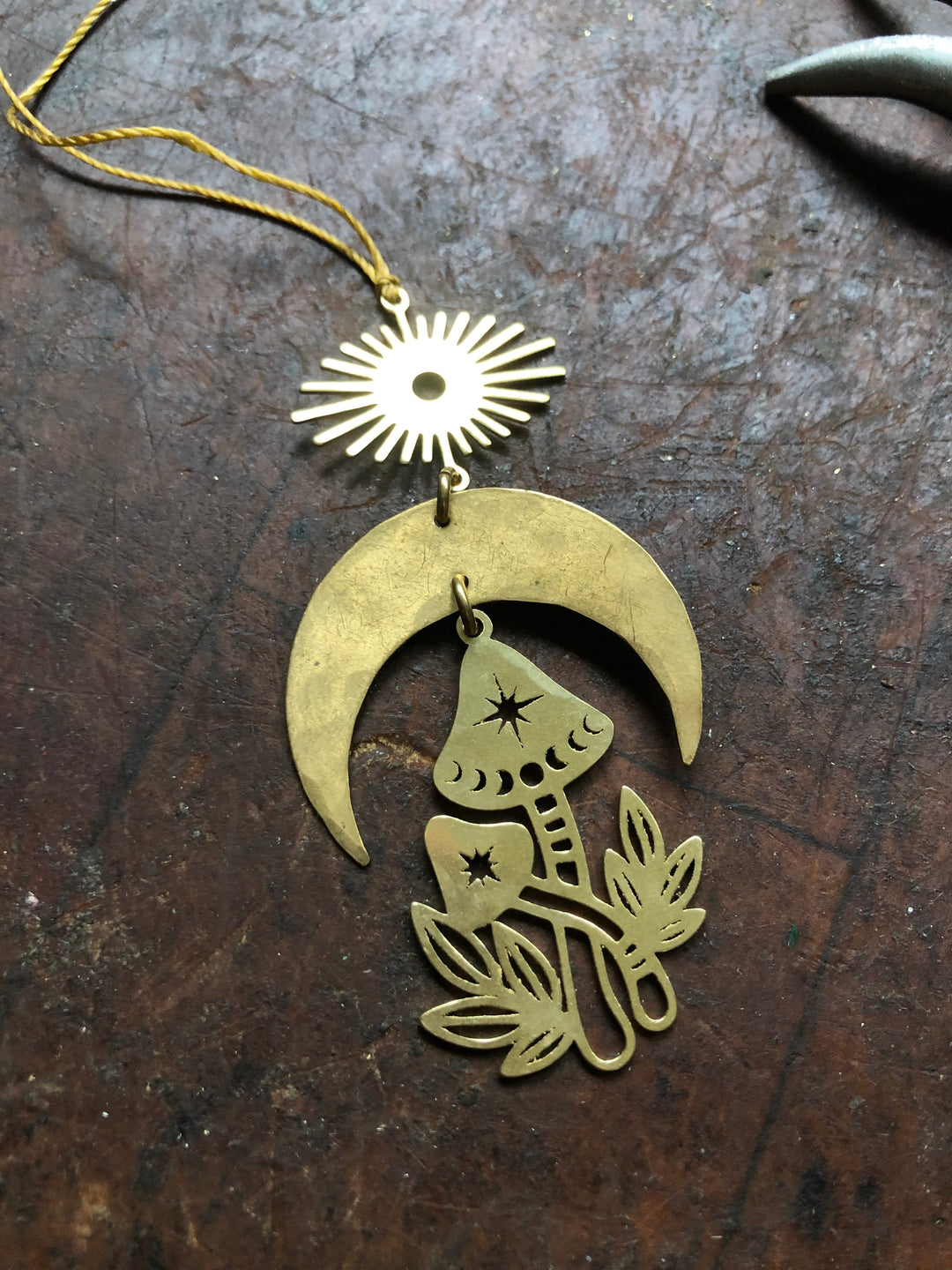 Gold mushroom ornament on crescent backing with hanging sun charm and star details