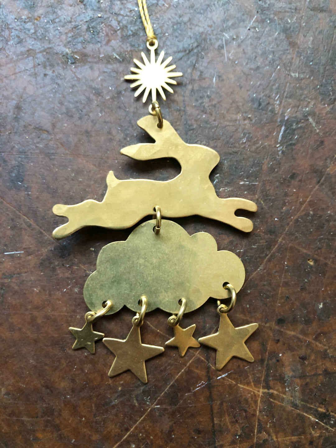 Layered metal ornament with sunburst top charm, cloud body and five dangling stars