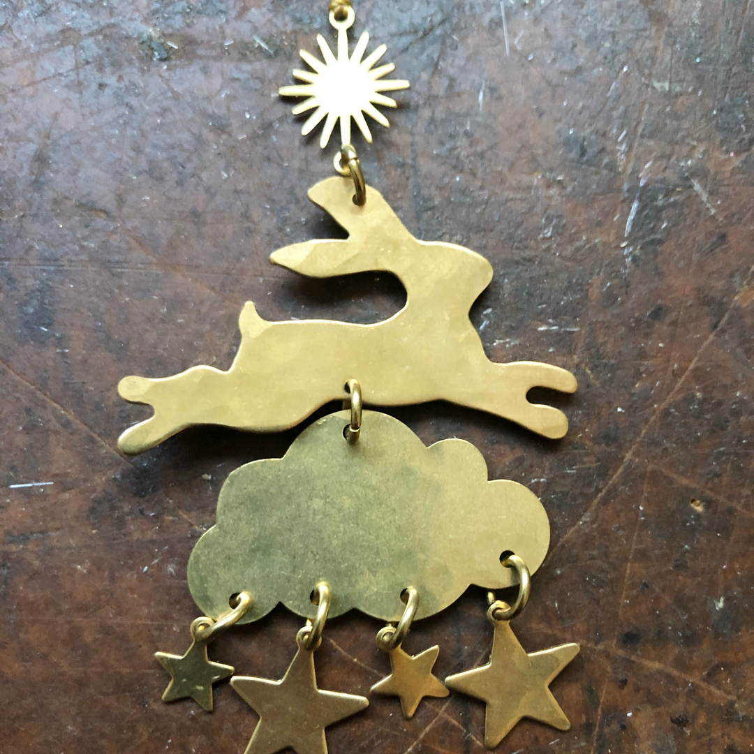 Layered metal holiday ornament with sunburst charm, tree-like silhouette and dangling stars
