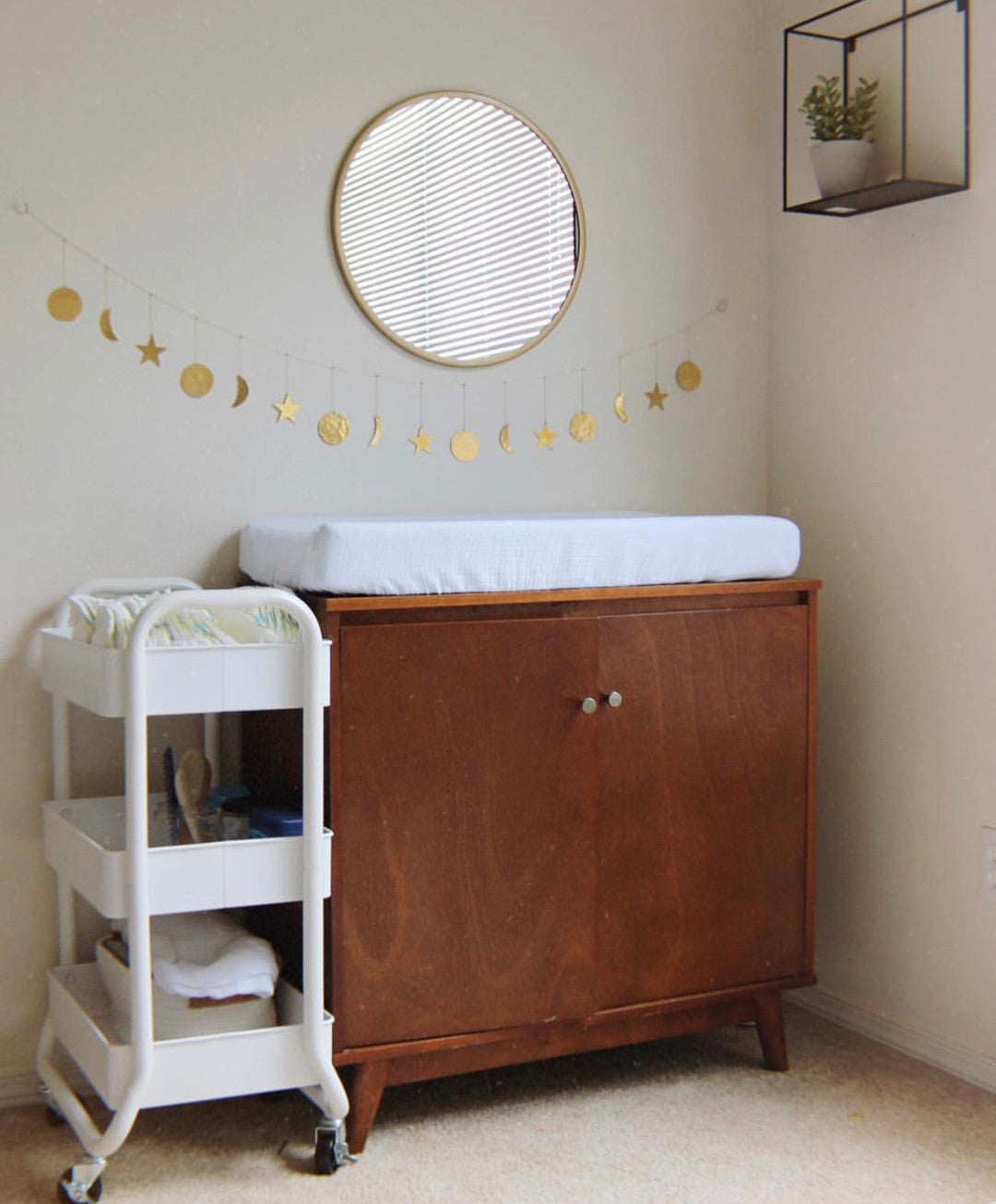 Hammered brass star and moon garland with round tags strung across the wall