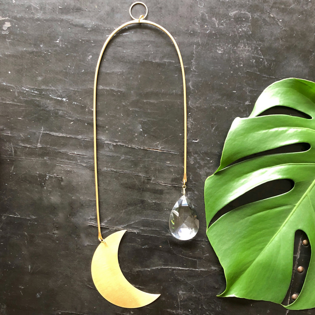 Metal moon suncatcher with dangling crystal teardrop charm and hanging ring loop.