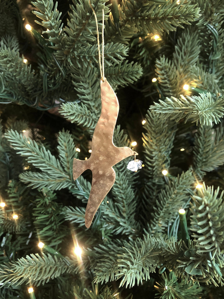Gold-toned hammered ornament with clear Herkimer diamond, hanging from tree branch