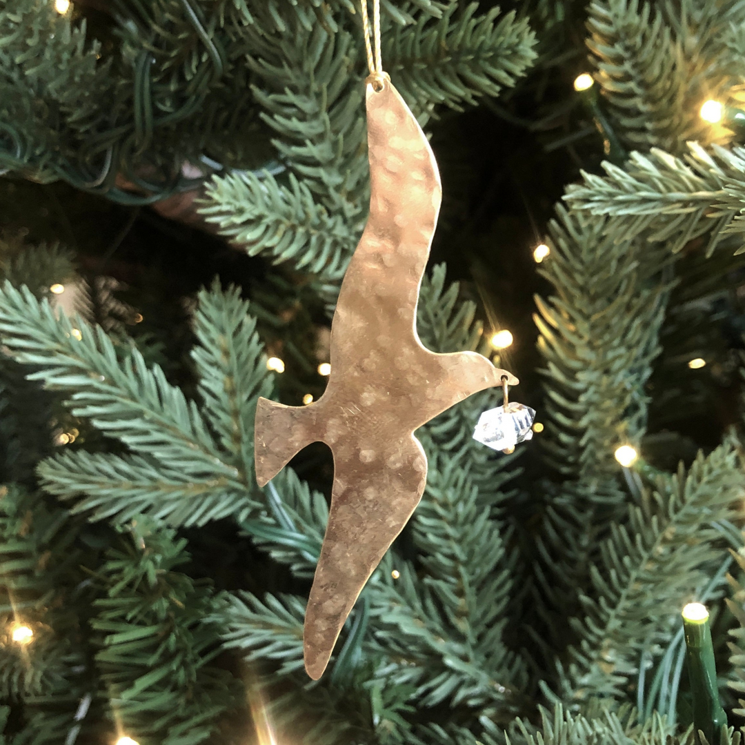 Gold-toned hammered ornament with clear Herkimer diamond, hanging on tree