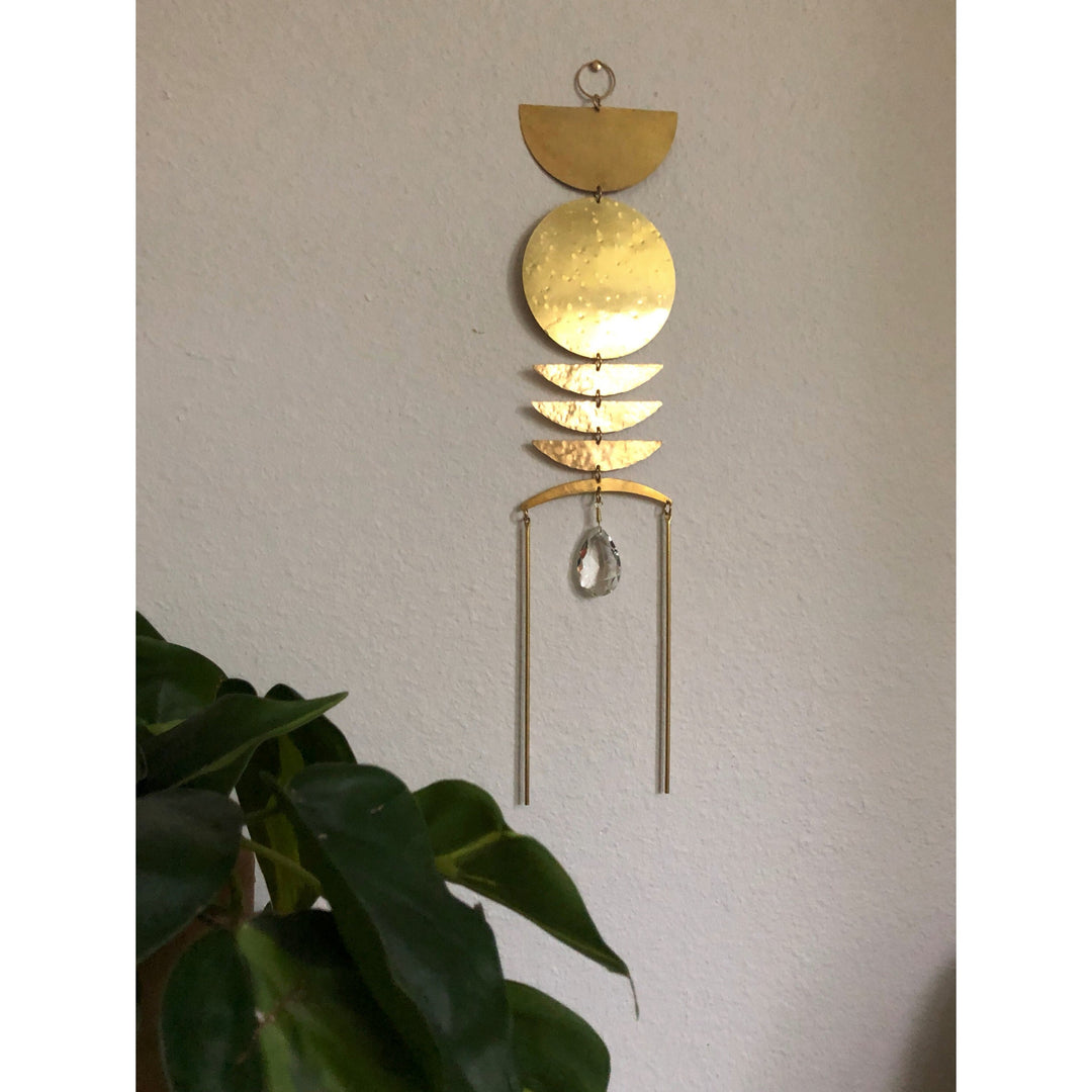 Gold sun catcher with stacked discs and crystal teardrop, hanging from a loop