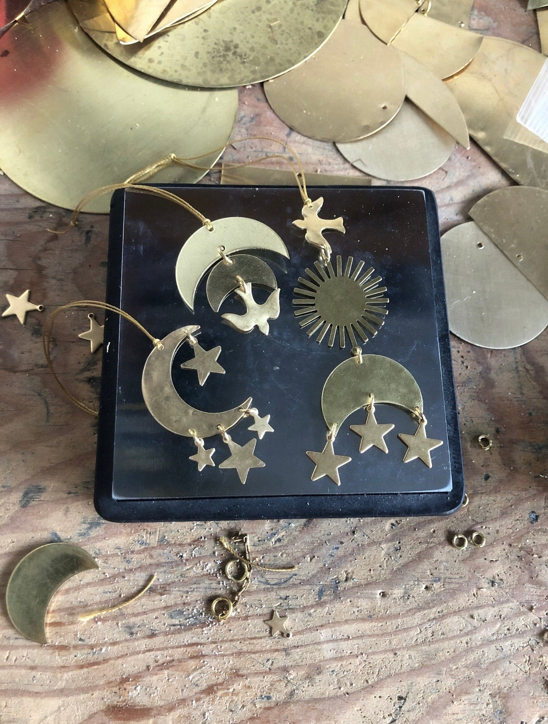 Gold constellation ornament set with crescent moon and star charms arranged on a tray