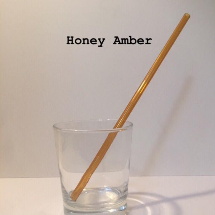 10-inch reusable straw in Honey Amber, shown diagonally in a clear drinking glass.