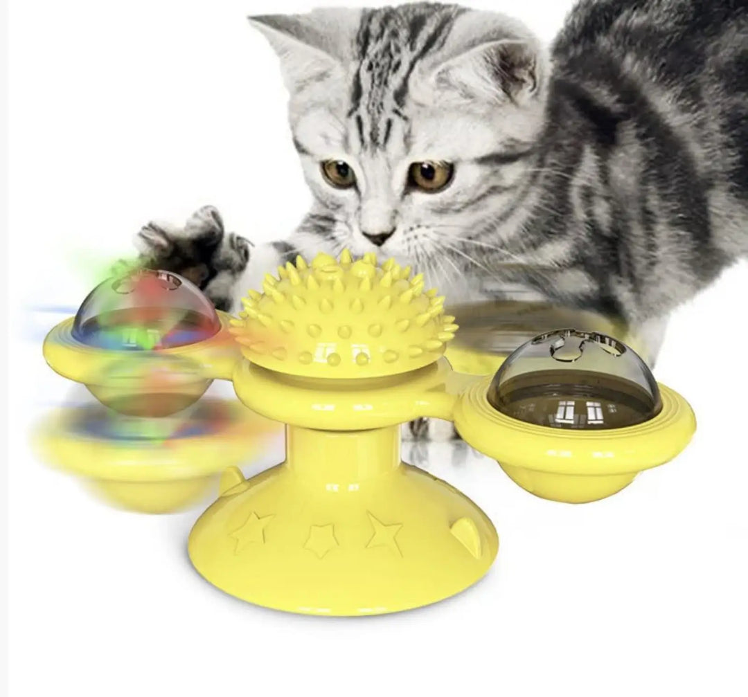 Yellow spinning windmill cat toy with spiked center and clear glowing LED domes