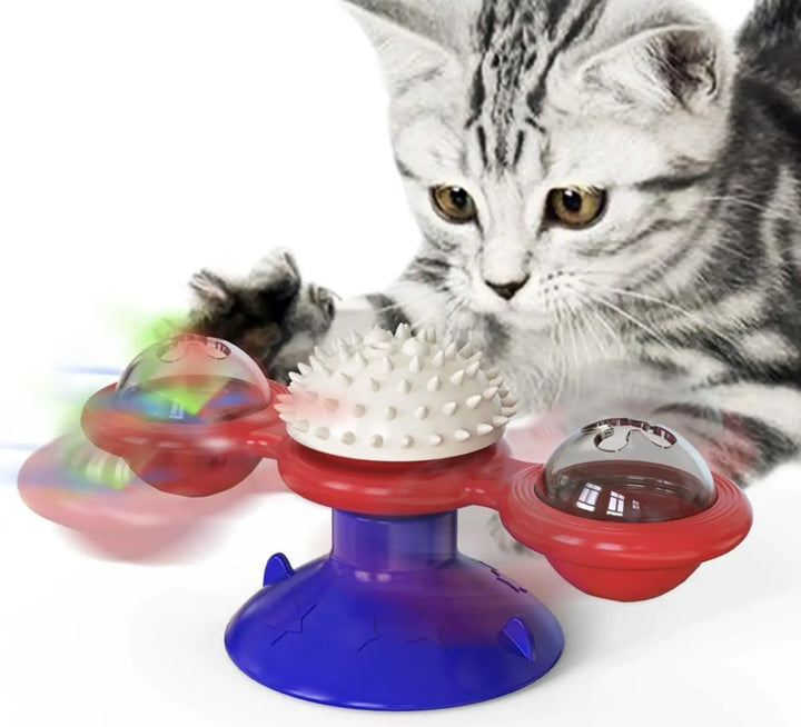 Spinning windmill cat toy with red and blue parts and clear LED ball; with tabby cat