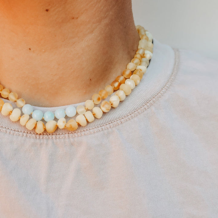 Amber bead necklace with yellow and white beads along the neckline