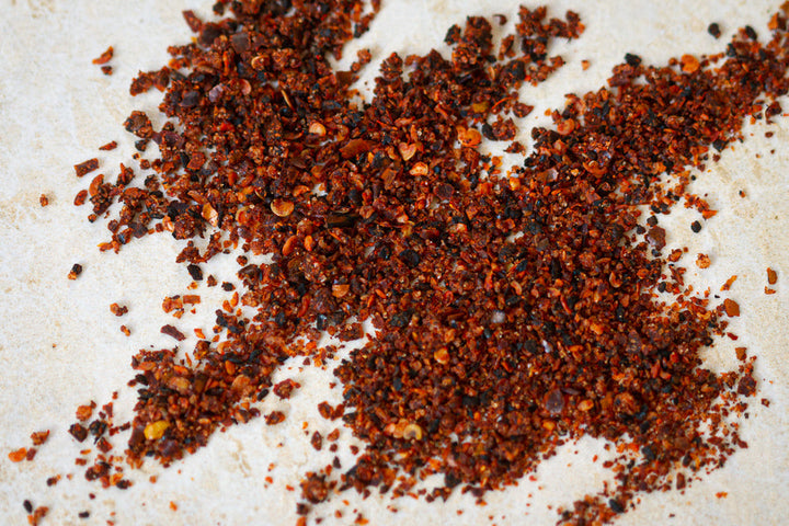 Ground chili-lime seasoning, dark red-brown specks in a small pile
