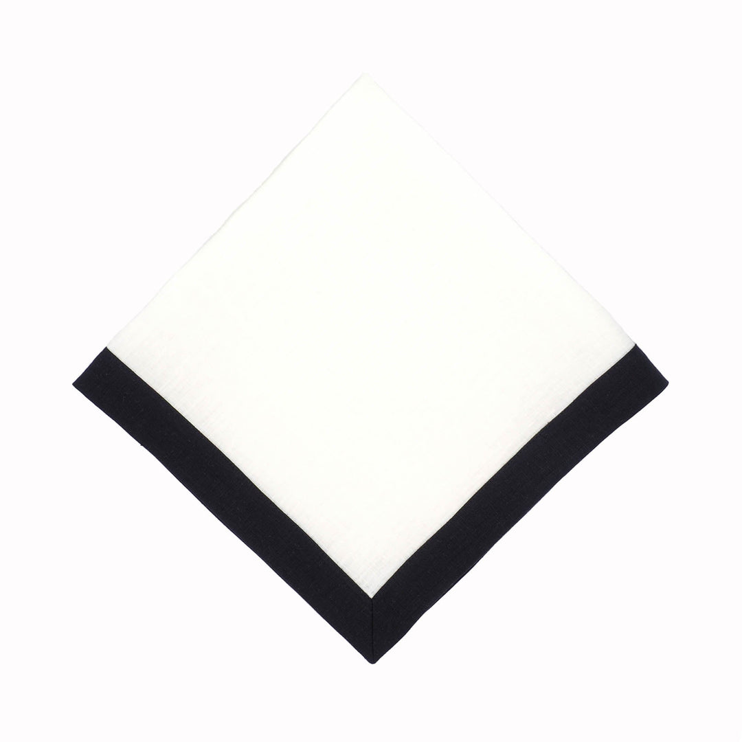 Folded linen napkin with white center and black border along the edges.