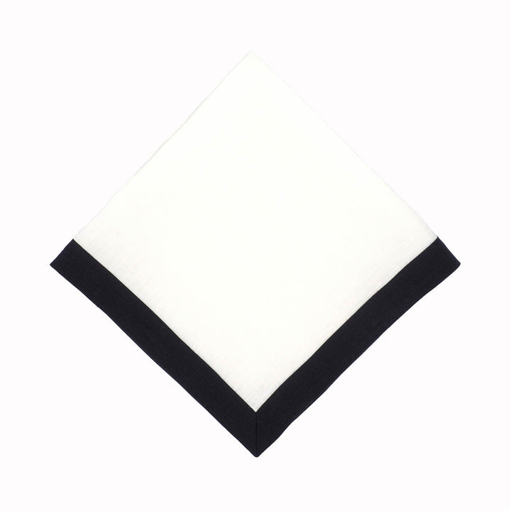 Folded linen napkin with white center and black border along the edges.