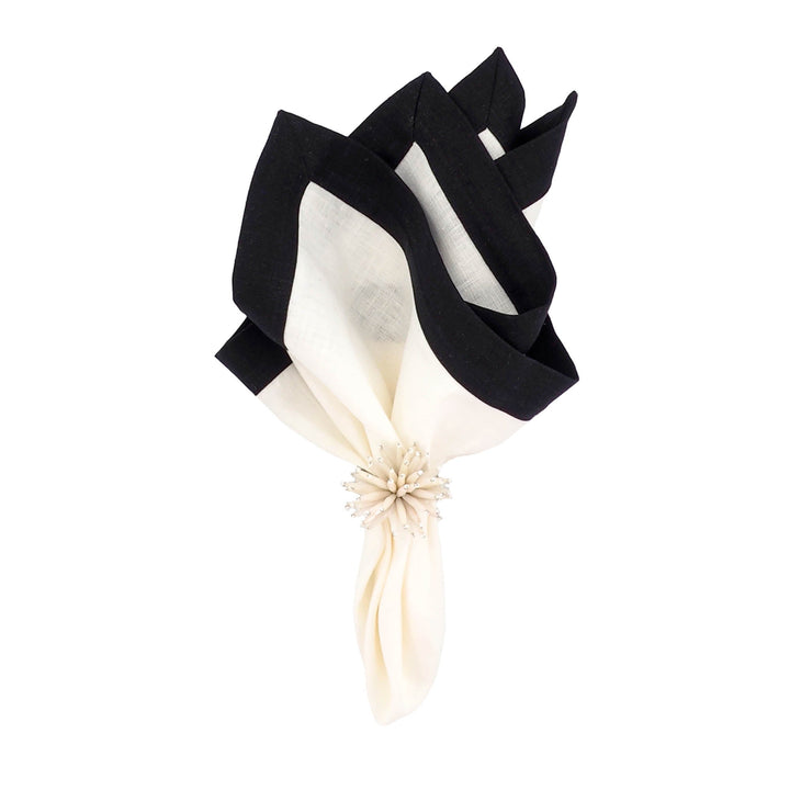 Folded linen napkin bouquet shape with white center and black outer border.