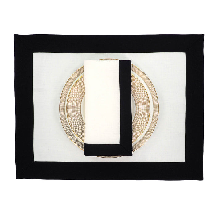 Rectangular linen napkins on a plate setting, white center with black border trim.