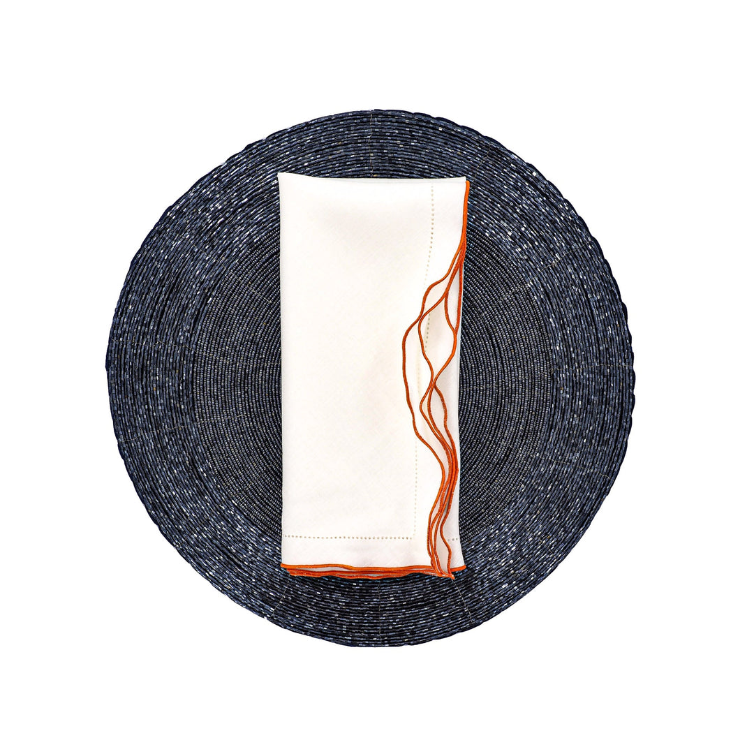 White linen napkin with orange ruffled hemstitch edge, folded rectangle
