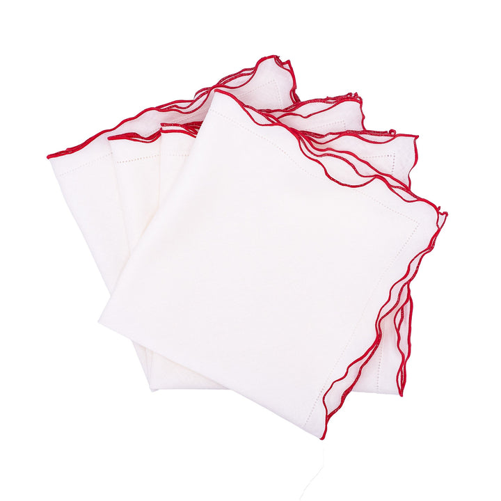 Set of white linen napkins with red ruffled hemstitch edges, folded stack