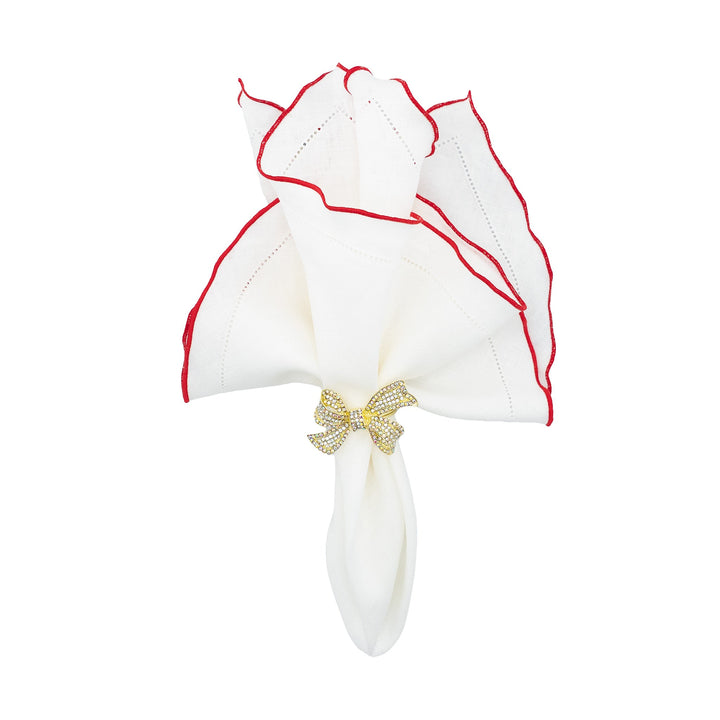 White linen napkins with red ruffled hemstitch edges, tied with gold bow