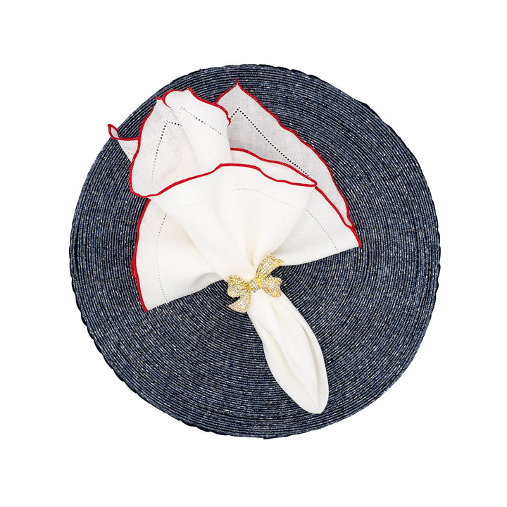 White linen napkins with red ruffled hemstitch edges, angled fold with gold bow tie