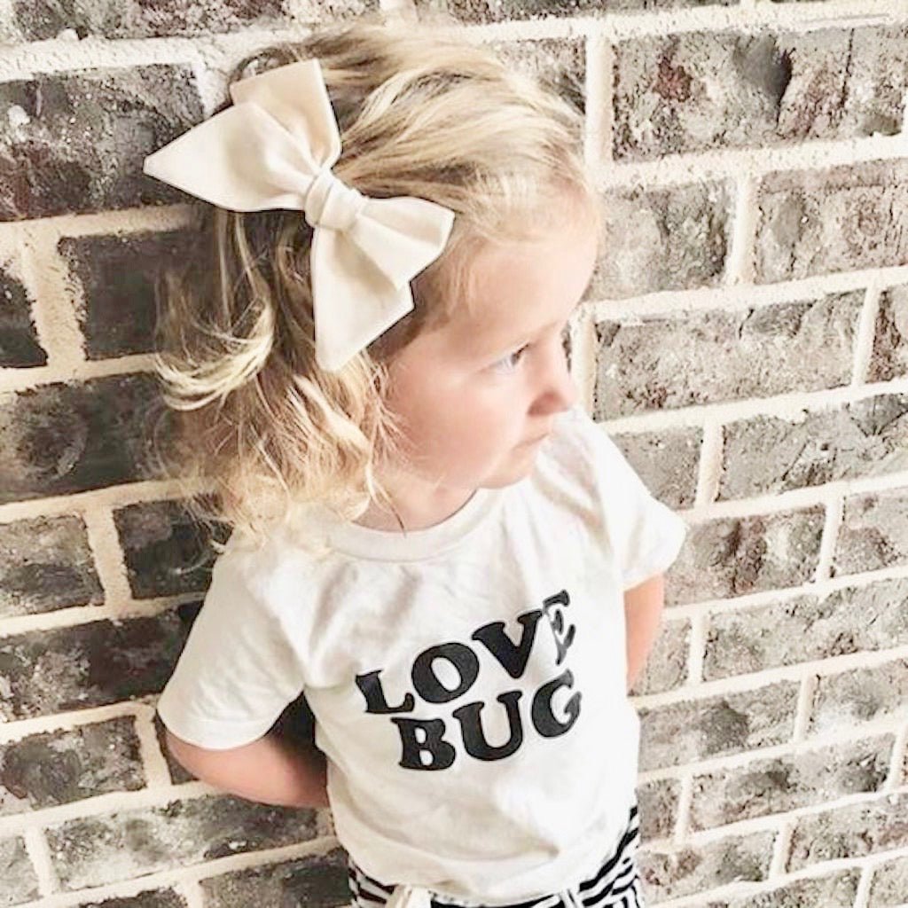Off-white kids organic T-shirt with "LOVE BUG" black print, short sleeves