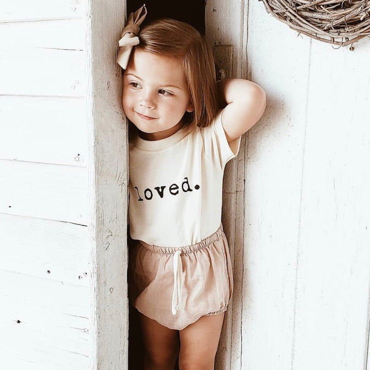 Kids organic T-shirt with “loved.” print at front and crew neck