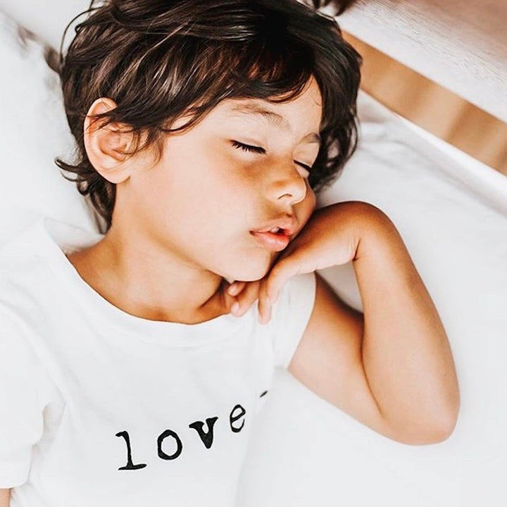 Kids organic T-shirt close-up with “loved.” print across chest