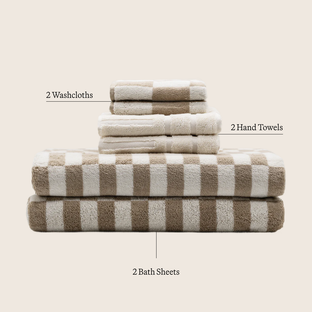 Stacked gray-and-ecru cotton towels and washcloths with check pattern.