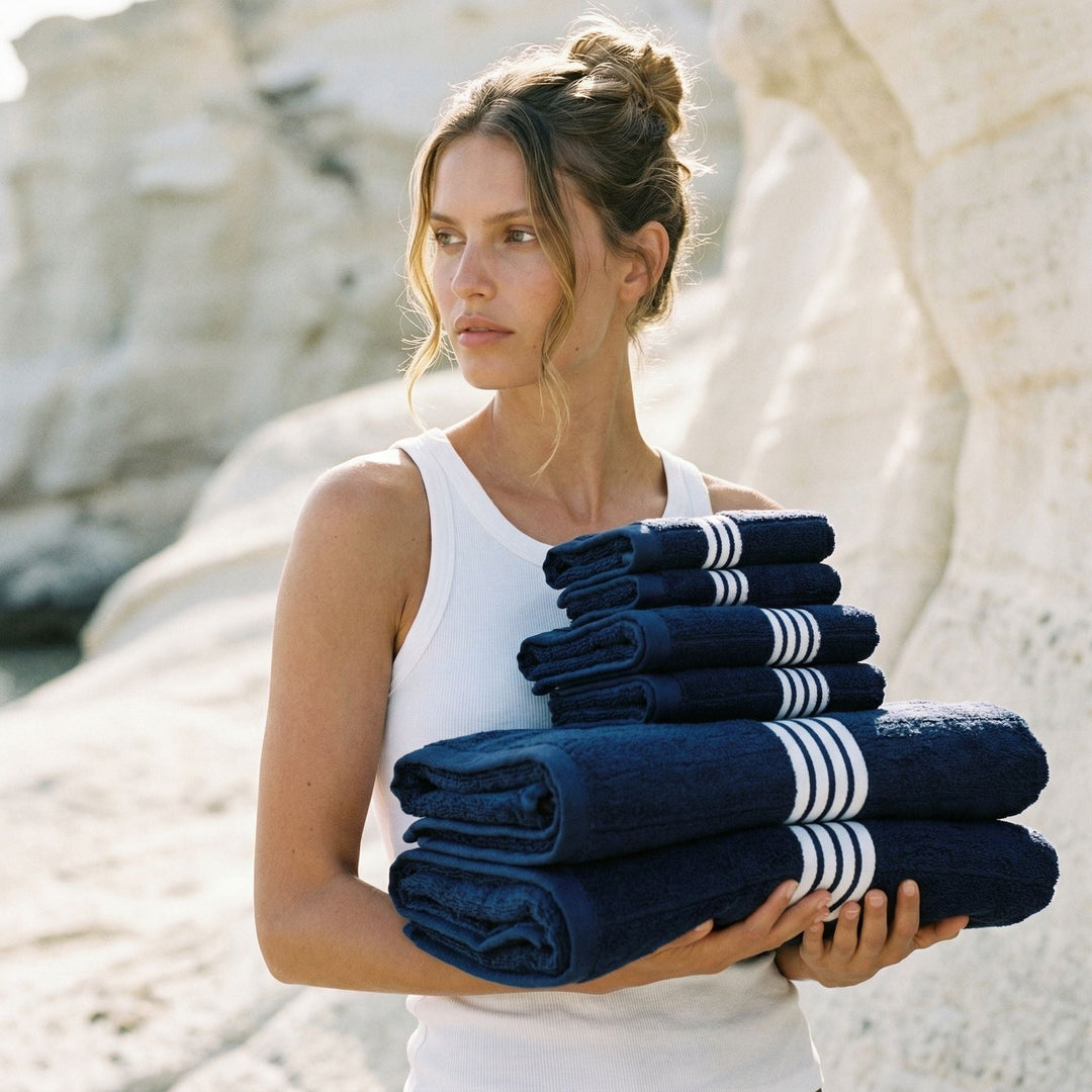 Stack of dark navy cotton towels with white stripe bands