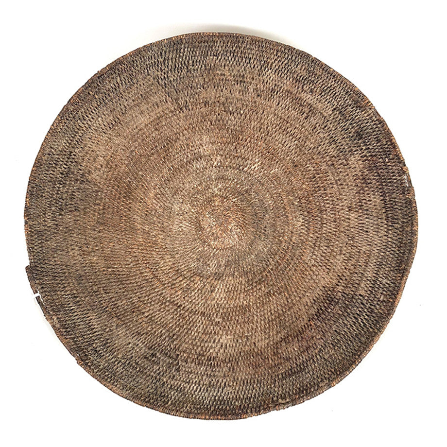 Round woven basket with centered medallion pattern and concentric thread texture