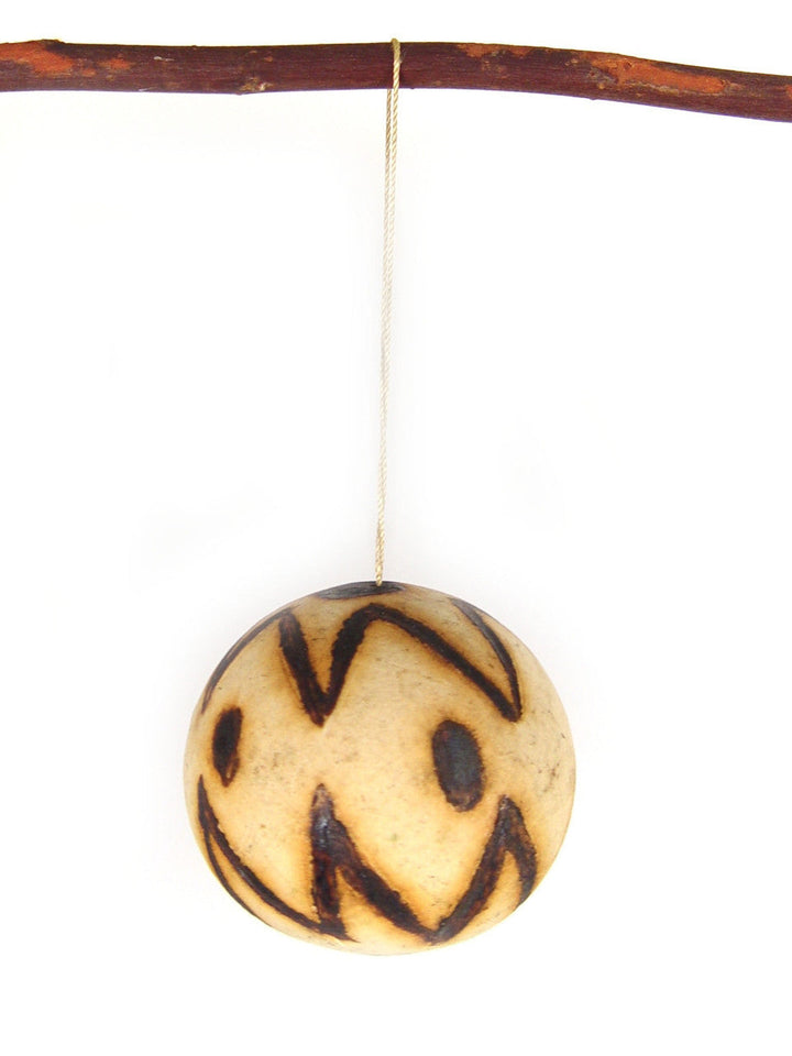 Marula fruit ornament: single round carved wooden bauble with dark zigzag and dot accents