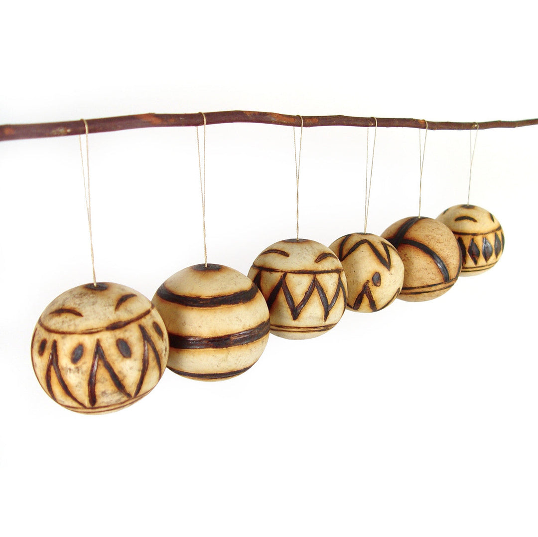 Marula fruit ornaments: row of round carved wooden baubles with tribal lines and stripe bands