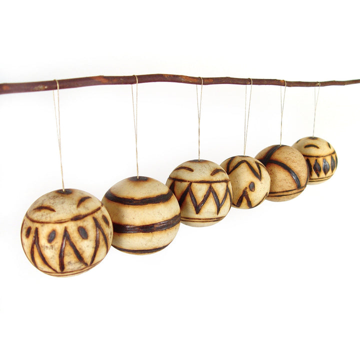 Marula fruit ornaments: row of round carved wooden baubles with tribal lines and stripe bands