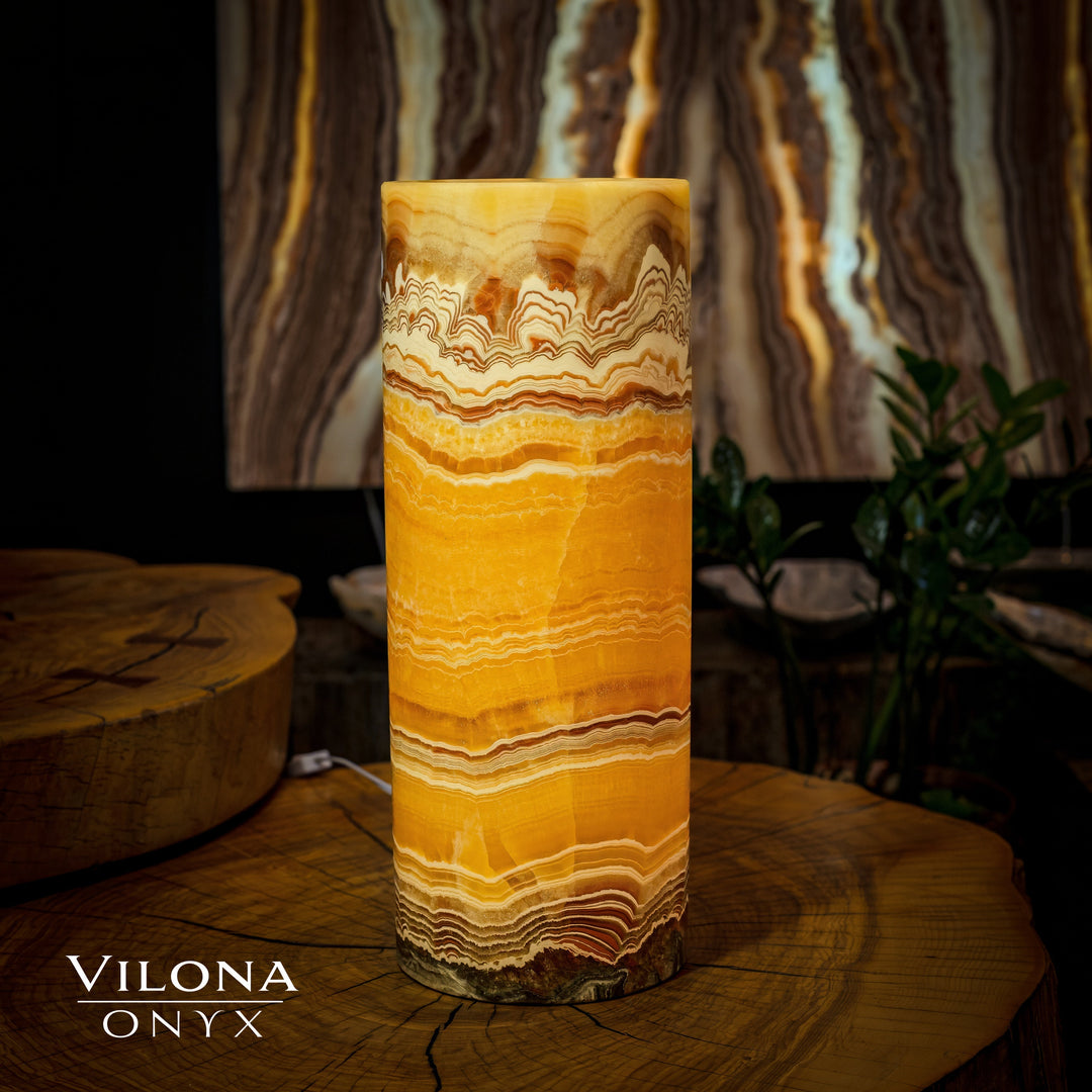 Onyx cylinder table lamp with warm amber light and horizontal banded stone