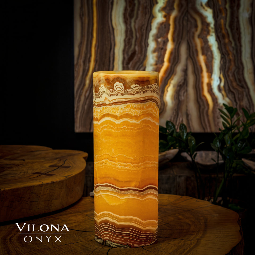 Onyx cylinder table lamp with warm amber glow and vertical wavy stone stripes