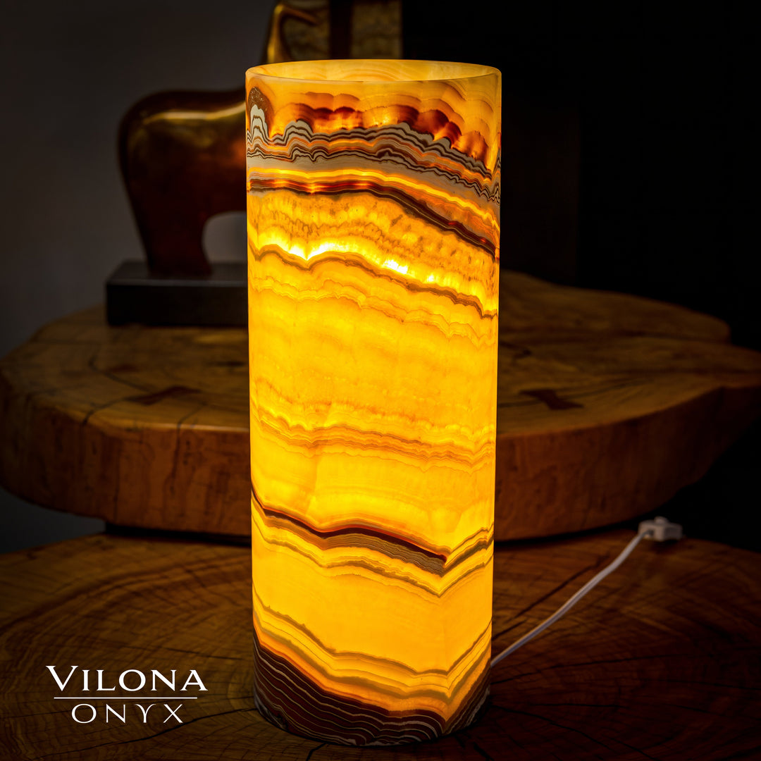 Onyx cylinder table lamp with glowing amber stripes and visible power cord