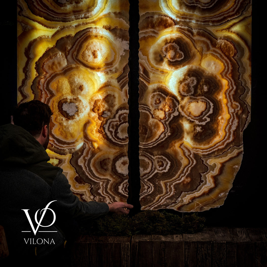 Close-up onyx wall panels with layered circular rings in amber and dark brown.
