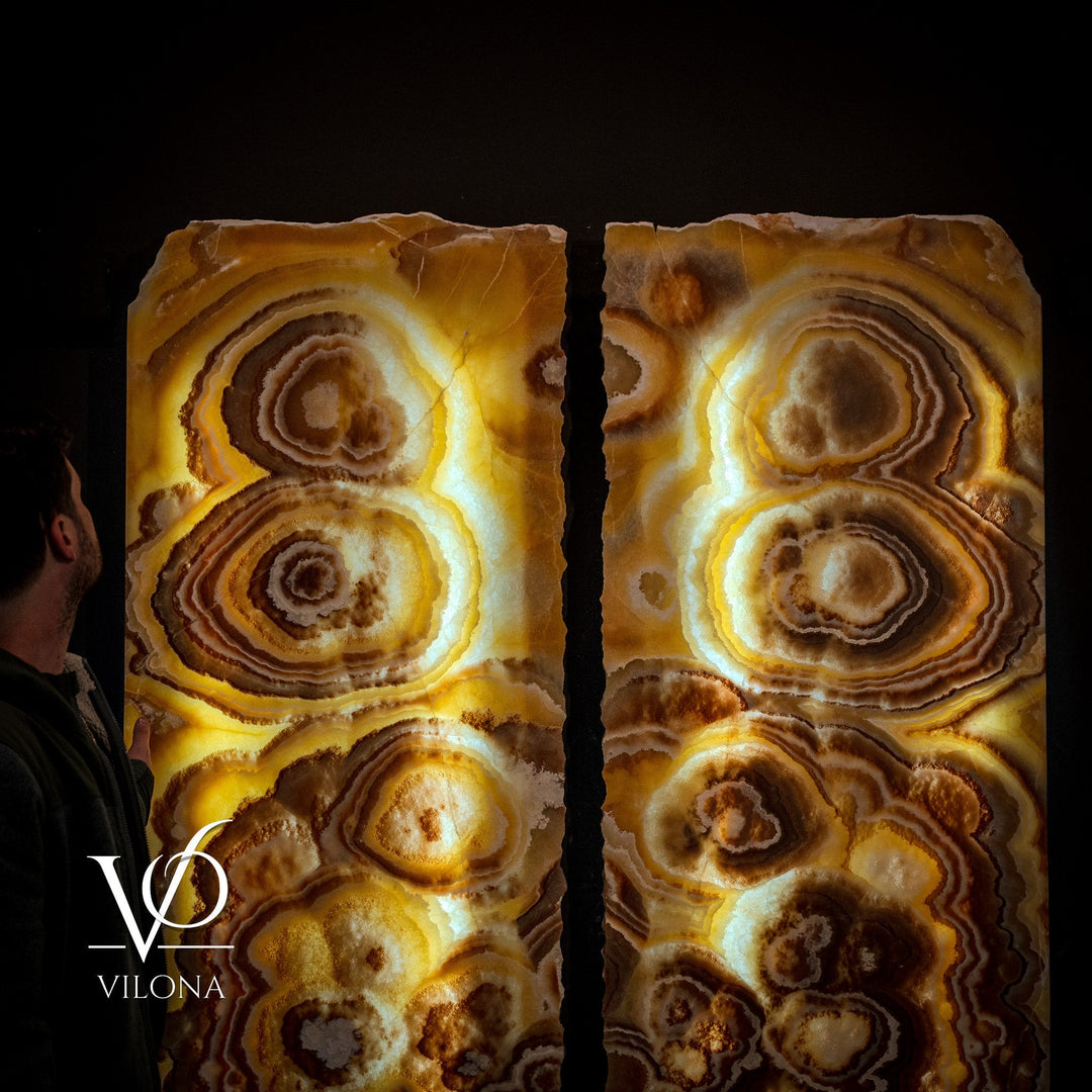 Paired onyx wall panels with bright gold highlights and concentric ring textures.
