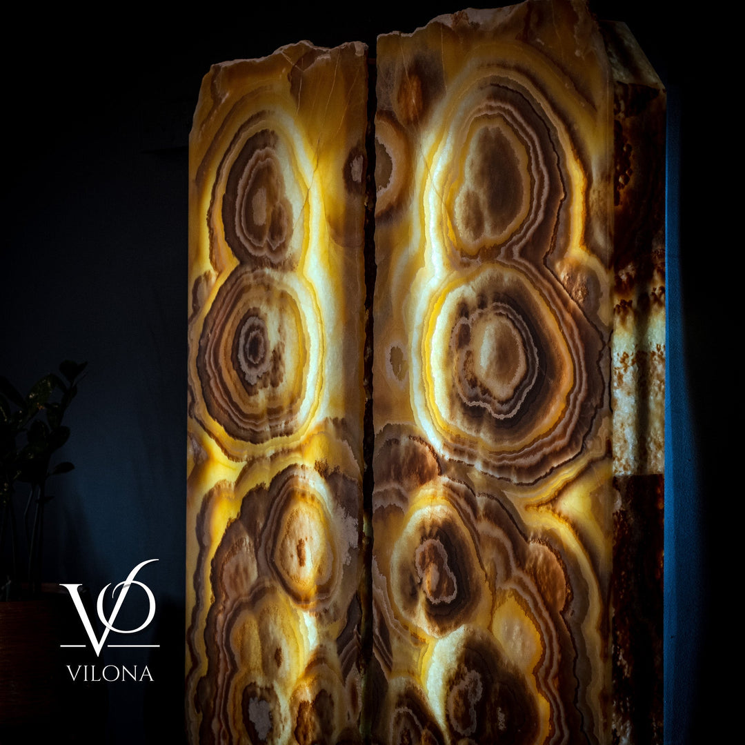 Pair of onyx wall panels with layered circular ring patterns in gold, tan, and brown.