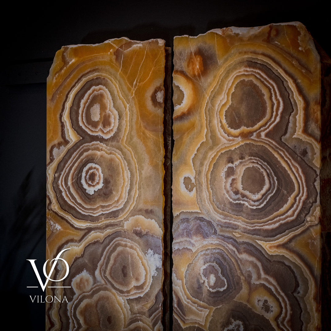Close-up of paired onyx wall panels with concentric circles in warm tan and brown.